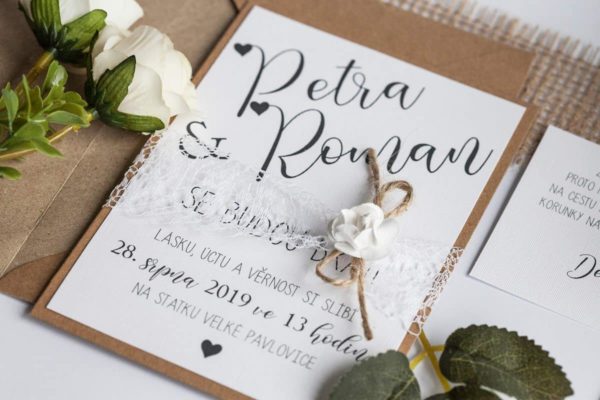 Rustikální svatební oznámení s krajkou a papírovou kytičkou na kraftovém papíře